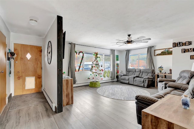 living room featuring ceiling fan, light wood-type flooring, and a baseboard radiator