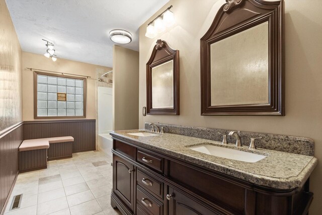 444 S Meridian Rd, Kalispell, MT 59901 - full bathroom with double vanity, wainscoting, bathing tub / shower combination, and tile patterned floors
