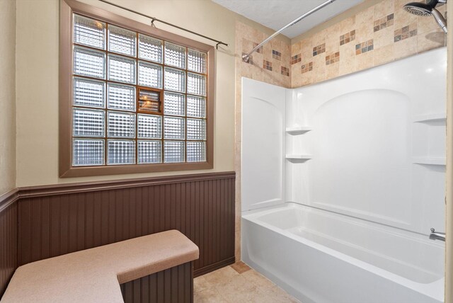 444 S Meridian Rd, Kalispell, MT 59901 - bathroom featuring wainscoting, tub / shower combination, tile patterned flooring, and healthy amount of natural light