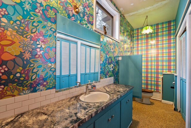 444 S Meridian Rd, Kalispell, MT 59901 - bathroom with wallpapered walls, vanity, toilet, and baseboards