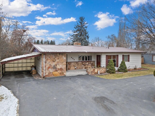 444 S Meridian Rd, Kalispell, MT 59901 - view of front of house featuring stone siding, driveway, and metal roof