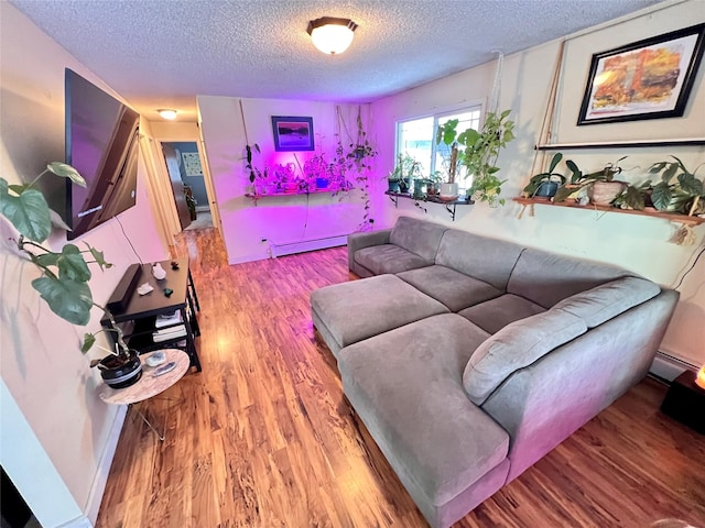 living room with light hardwood / wood-style floors, a textured ceiling, and a baseboard heating unit