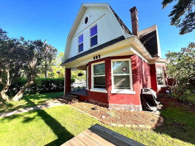 view of side of property with a yard and a porch