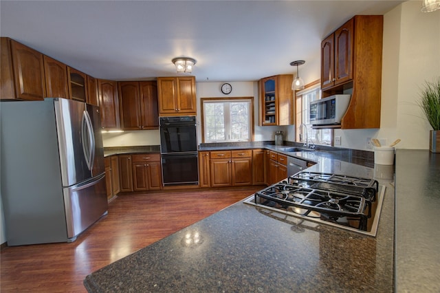 kitchen featuring pendant lighting, dark hardwood / wood-style flooring, stainless steel appliances, and sink