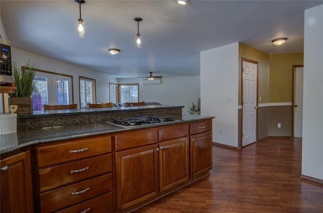 kitchen with ceiling fan, dark wood-type flooring, decorative light fixtures, and stainless steel gas stovetop