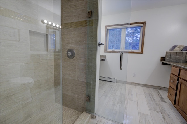 bathroom featuring vanity, baseboard heating, and a shower with shower door