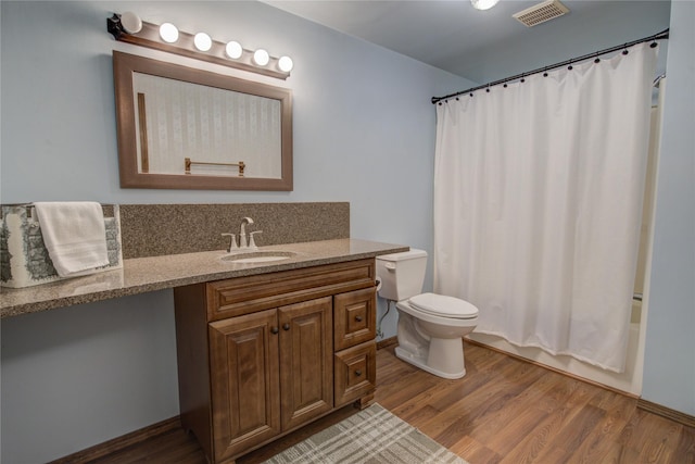 full bathroom with hardwood / wood-style flooring, vanity, toilet, and shower / bath combo with shower curtain