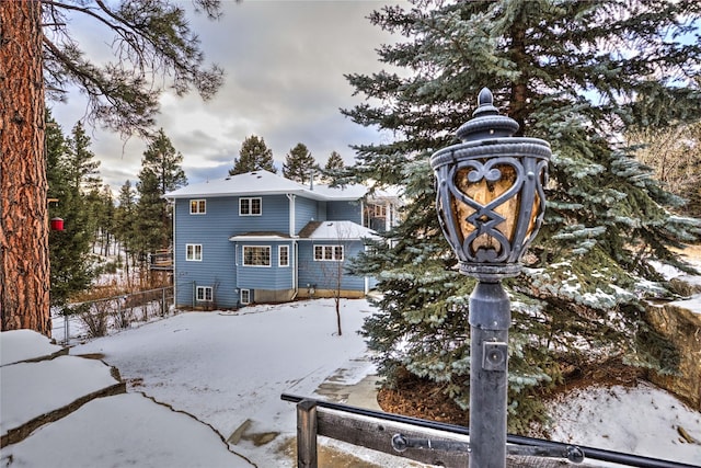 view of snow covered back of property