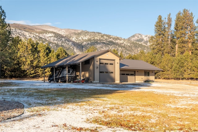 view of outbuilding with a carport, a mountain view, and a garage