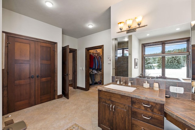 bathroom featuring decorative backsplash, vanity, tile patterned floors, and walk in shower