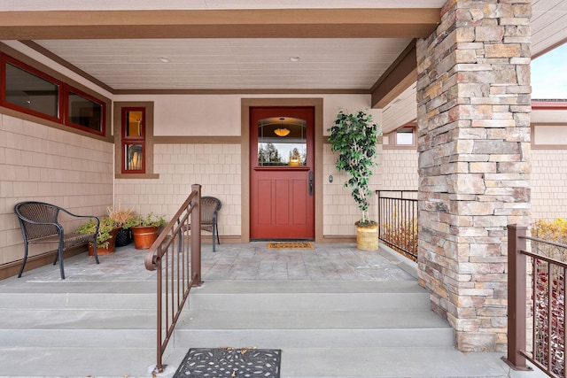 view of exterior entry featuring covered porch