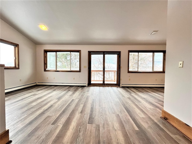 unfurnished living room with light hardwood / wood-style floors and a baseboard heating unit