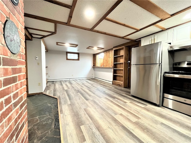 kitchen with brick wall, stainless steel appliances, extractor fan, light hardwood / wood-style flooring, and white cabinetry