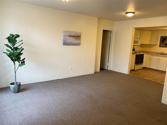 interior space with sink, hardwood / wood-style flooring, white cabinetry, and electric stove