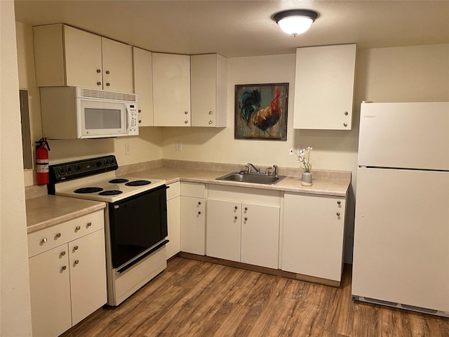 kitchen featuring hardwood / wood-style flooring, white cabinetry, white appliances, and sink