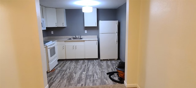 kitchen featuring hardwood / wood-style flooring, white cabinets, white appliances, and sink