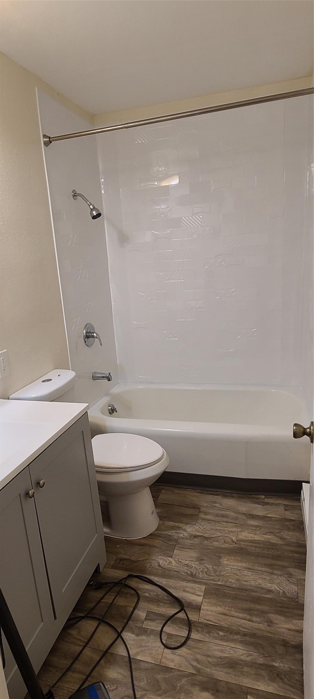 full bathroom with shower / bathing tub combination, vanity, wood-type flooring, and toilet