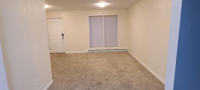 empty room with light colored carpet and a baseboard heating unit