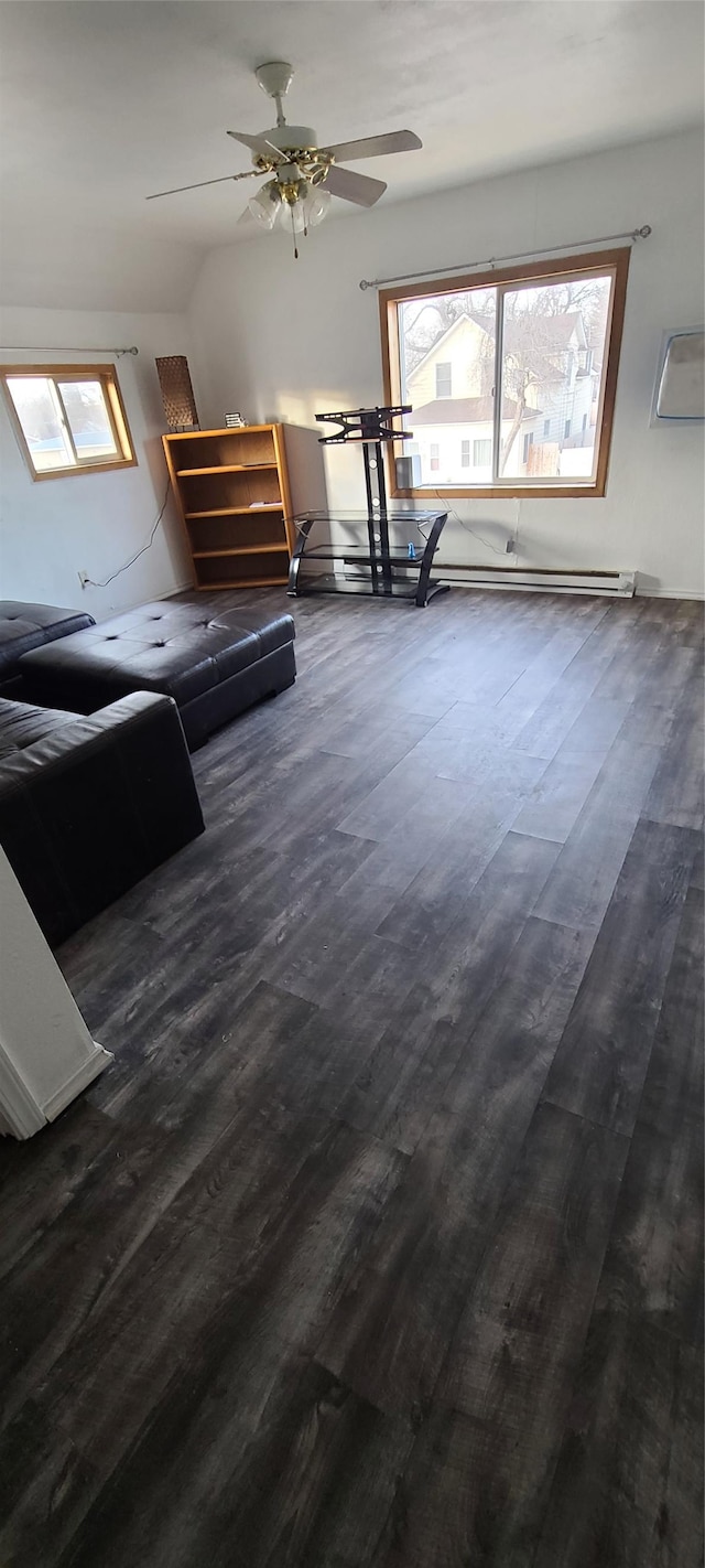 unfurnished living room with a wealth of natural light, ceiling fan, and dark wood-type flooring