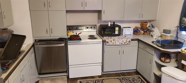 kitchen with dark hardwood / wood-style flooring, stainless steel dishwasher, sink, electric range, and white cabinetry