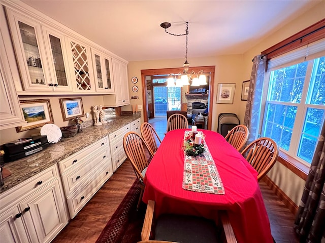 dining room with plenty of natural light, a fireplace, and a chandelier