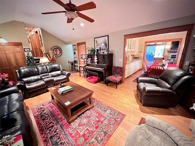 living room featuring ceiling fan, light hardwood / wood-style flooring, and lofted ceiling