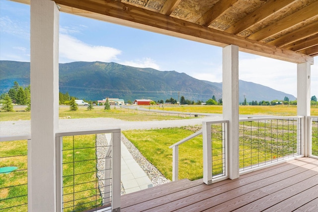 deck featuring a mountain view, a rural view, and a yard