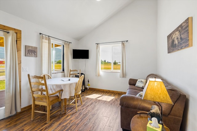 dining space with plenty of natural light, high vaulted ceiling, and dark hardwood / wood-style floors