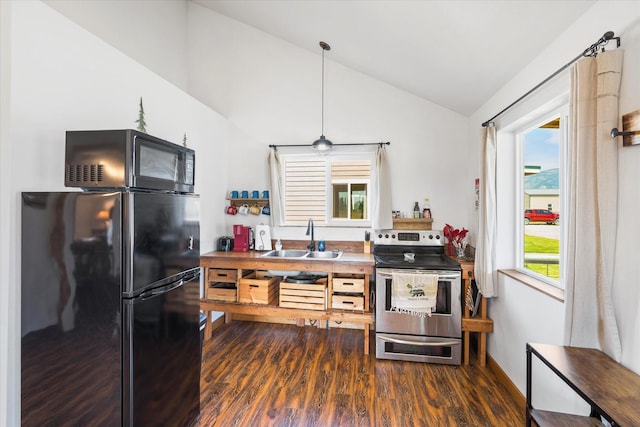 kitchen featuring a healthy amount of sunlight, refrigerator, vaulted ceiling, and electric range