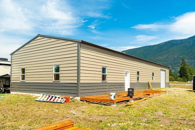 view of side of home featuring a mountain view and a yard