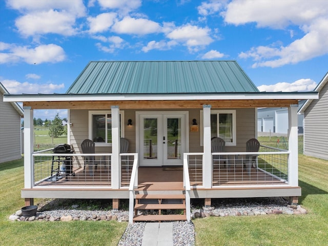 view of front of property with covered porch, french doors, and a front lawn