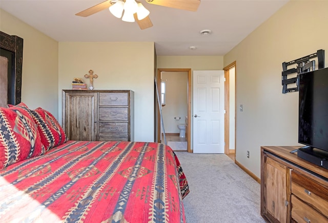 bedroom with connected bathroom, light colored carpet, and ceiling fan