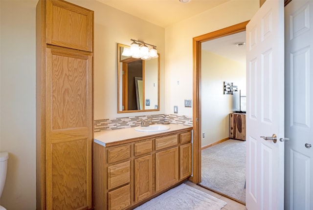 bathroom with vanity, toilet, and backsplash