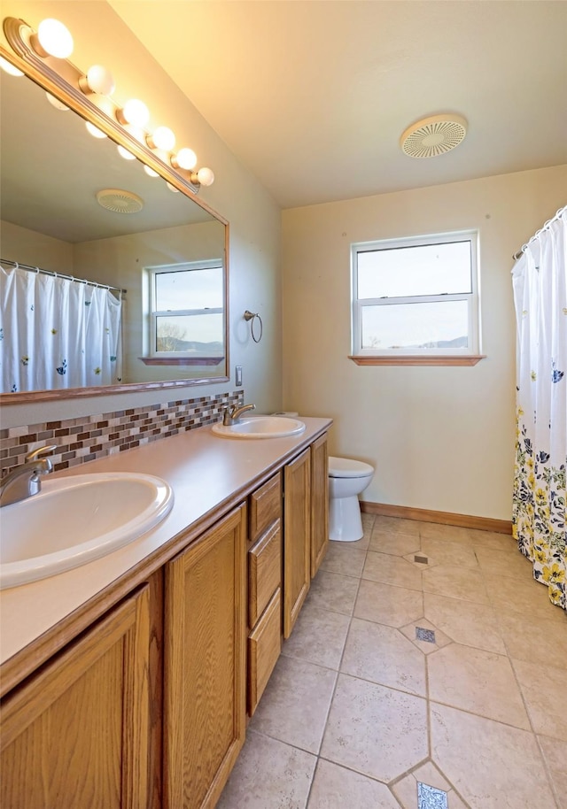 bathroom featuring tile patterned floors, vanity, toilet, and backsplash