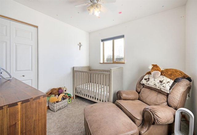 carpeted bedroom featuring ceiling fan, a closet, and a nursery area