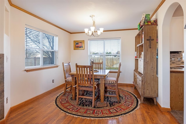 dining area featuring a notable chandelier, crown molding, and light hardwood / wood-style flooring