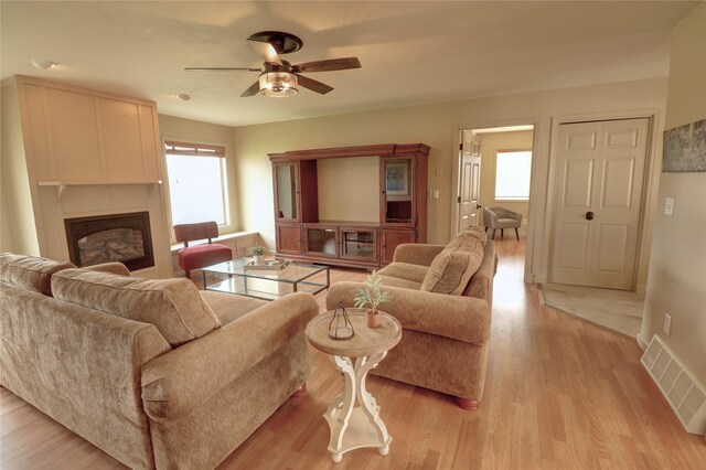 living room with ceiling fan and light wood-type flooring