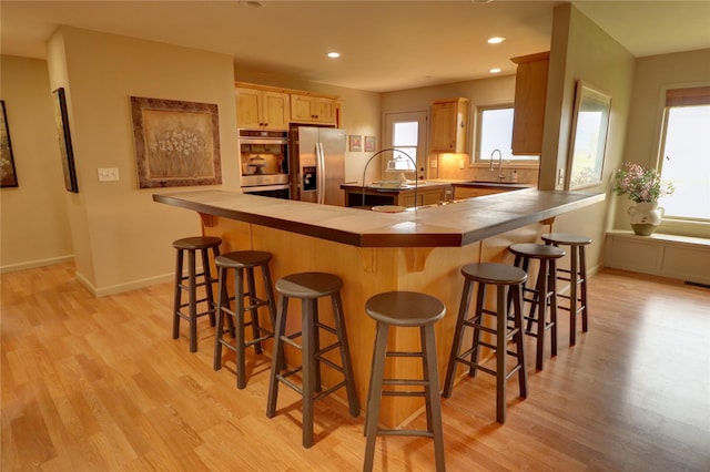 kitchen featuring appliances with stainless steel finishes, sink, a breakfast bar area, and kitchen peninsula