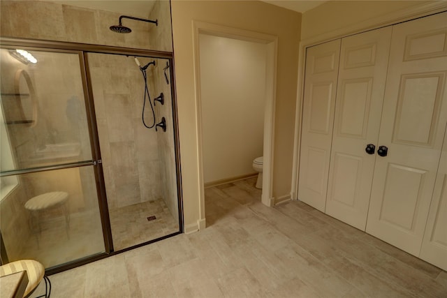 bathroom with an enclosed shower and toilet