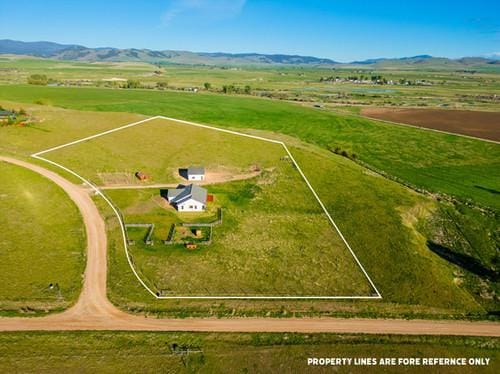 birds eye view of property with a mountain view and a rural view