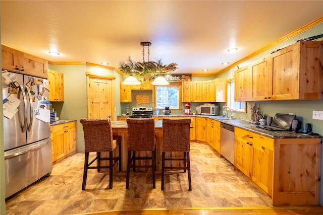 kitchen featuring appliances with stainless steel finishes, crown molding, sink, a center island, and a breakfast bar area