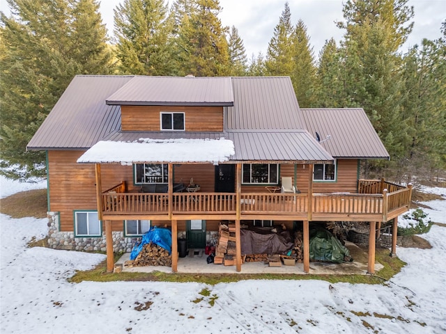 snow covered rear of property featuring a deck