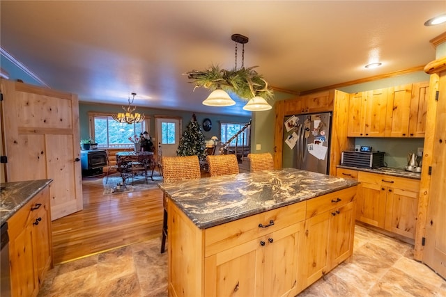 kitchen with a center island, hanging light fixtures, light hardwood / wood-style flooring, a notable chandelier, and appliances with stainless steel finishes