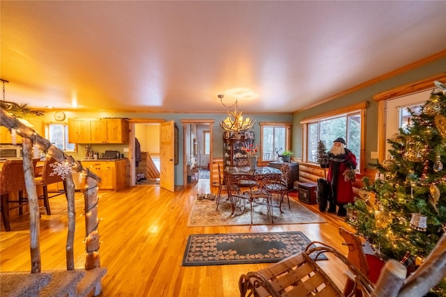 dining room featuring a chandelier, ornamental molding, and light hardwood / wood-style flooring