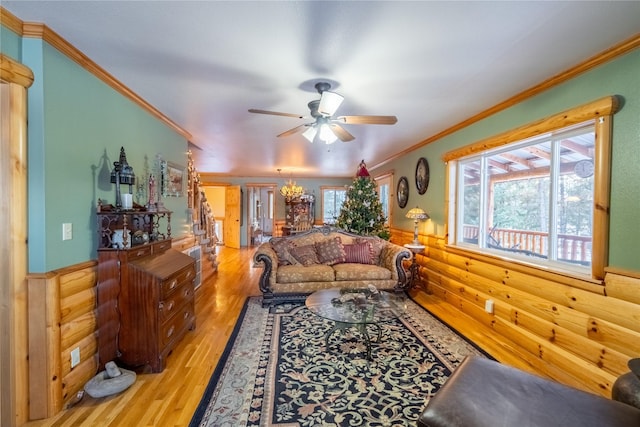 living room with a wealth of natural light, crown molding, light hardwood / wood-style floors, and ceiling fan with notable chandelier