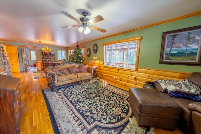 living room with hardwood / wood-style floors, ceiling fan with notable chandelier, crown molding, and a wealth of natural light