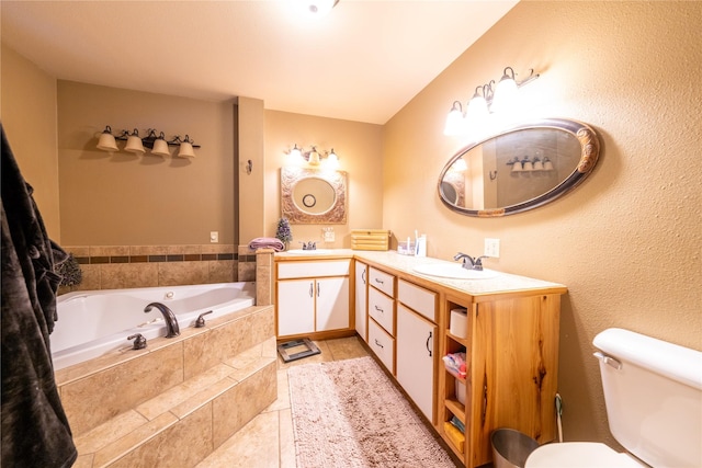 bathroom with tile patterned flooring, vanity, toilet, and tiled bath