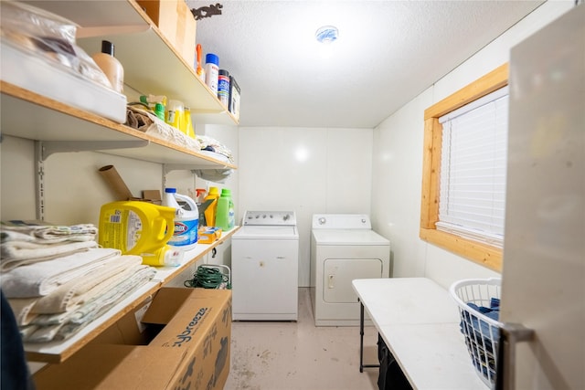 laundry area with independent washer and dryer and a textured ceiling