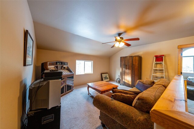 living room with carpet floors, vaulted ceiling, ceiling fan, and a healthy amount of sunlight