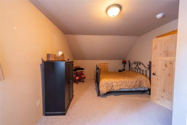 bedroom with carpet floors and lofted ceiling